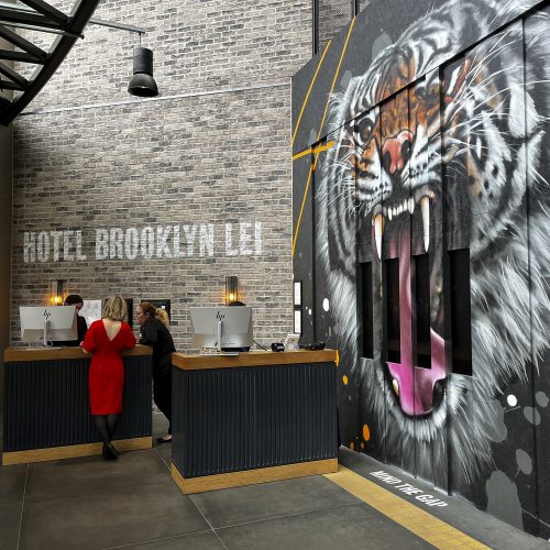 Reception - room with large tiger painting on wall and woman in red dress by black desk